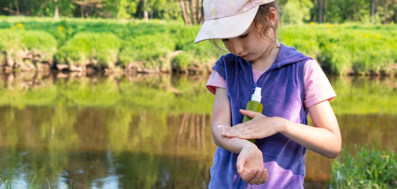 Visuel : un enfant étale de la crème sur son bras afin de se protéger des piqûres de moustique