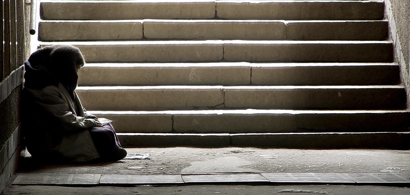 Illustration d'une personne en situation de précarité qui fait la manche à l'entrée d'un métro